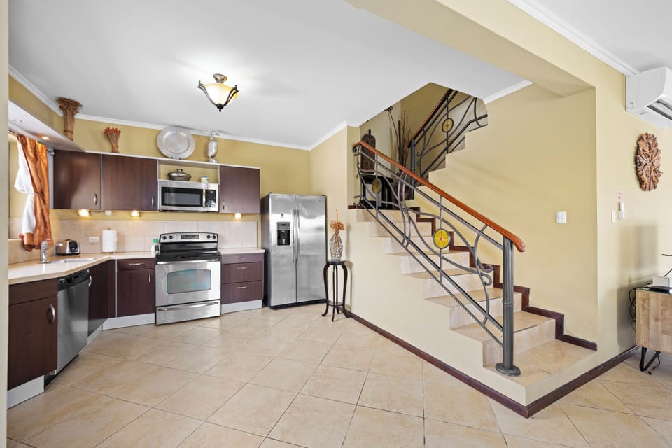 - Experience the harmonious blend of the open kitchen and staircase in our Noord Aruba townhouse - Admire the architectural elegance of the kitchen, illuminated by natural light - Indulge in the convenience of contemporary appliances at your disposal