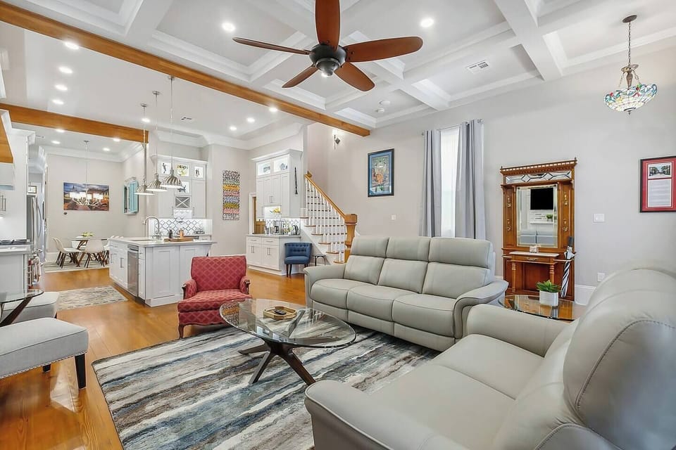 The den/living room provides ample space with 12' coffered ceilings, a 65" smart TV, blackout curtains, and comfortable leather recliners.