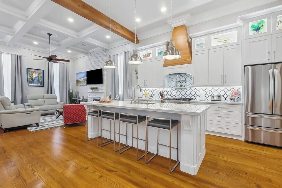 Spacious kitchen with large island seating for four, 12' ceilings, red gas commercial range, a coffee bar and a wine bar.