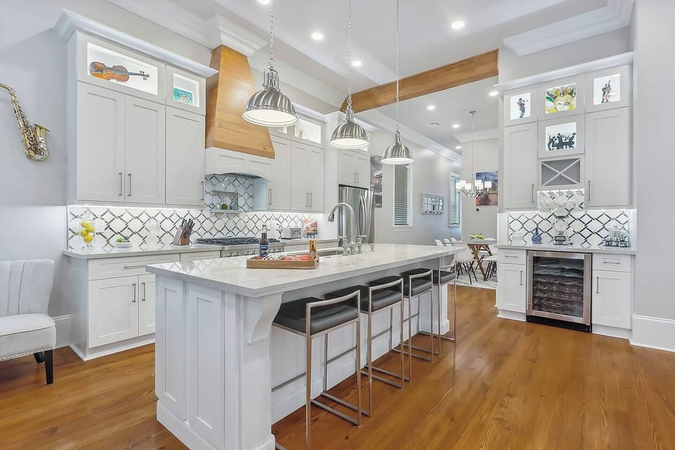 Spacious kitchen with large island seating for four, 12' ceilings, red gas commercial range, a coffee bar and a wine bar.