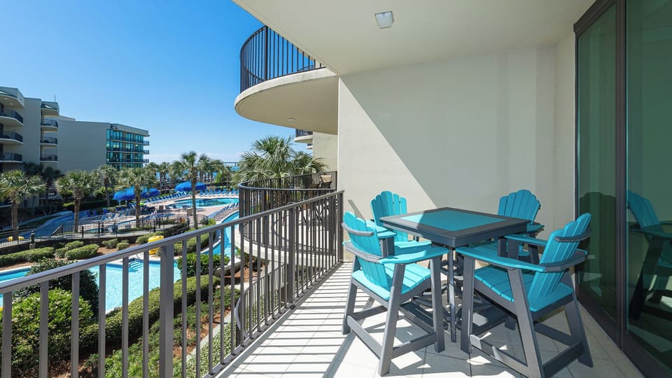 Breathe in the fresh air as you relax on the balcony, surrounded by lush greenery and serene pool views