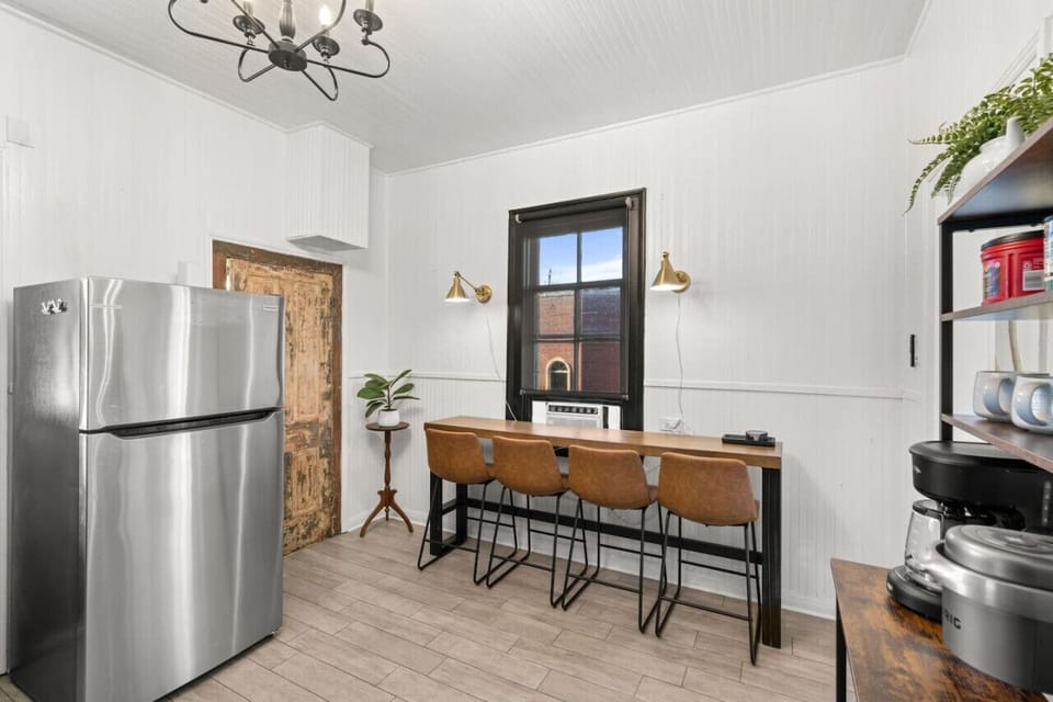 Modern kitchen with seating and appliances.