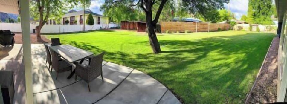 Enjoy outdoor meals and games in the private, expansive backyard at Green Oasis, your perfect Kanab retreat!