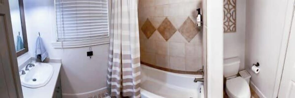Refresh and relax in the well-appointed bathroom at Green Oasis, featuring a tub-shower and bright vanity.