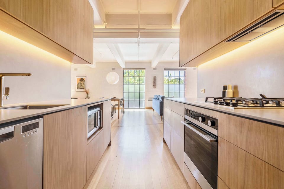 KITCHEN: Featuring rich Tasmanian Oak cupboards stocked with essentials and modern appliances, this kitchen is perfectly equipped for exploring Melbourne’s vibrant culinary scene or enjoying simple, delicious meals at home.