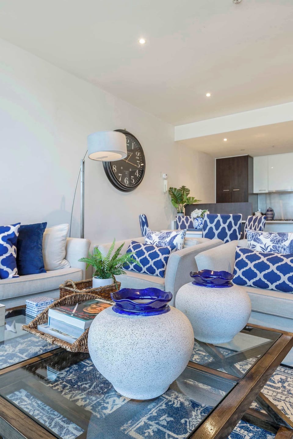 LIVING AREA: Sunlight fills the space through floor-to-ceiling windows, offering sweeping views of the Docklands waterfront. With plush seating and a calm, open feel, it’s the perfect spot for slow mornings, quiet reads, or laid-back evenings.