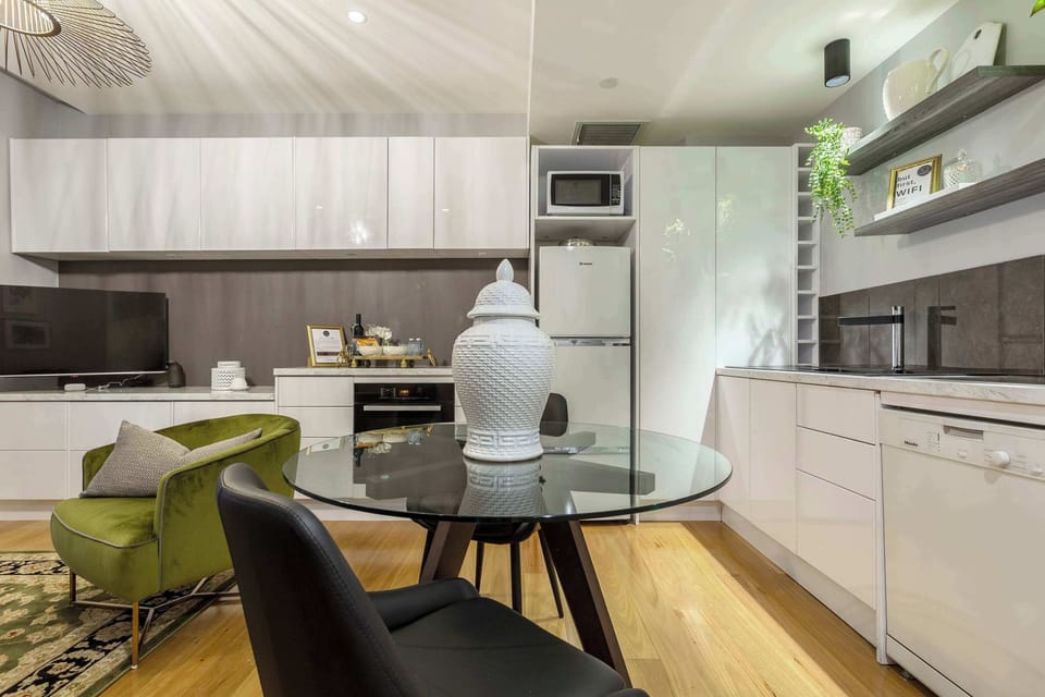 Stylish dining area with a glass table and comfortable seating, seamlessly connected to the cozy living space