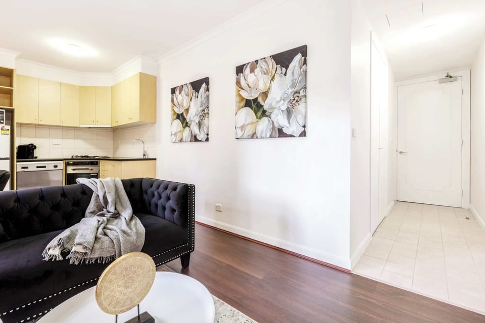 Open-plan living area with modern décor, cozy seating, and easy access to the kitchen, perfect for relaxing or entertaining