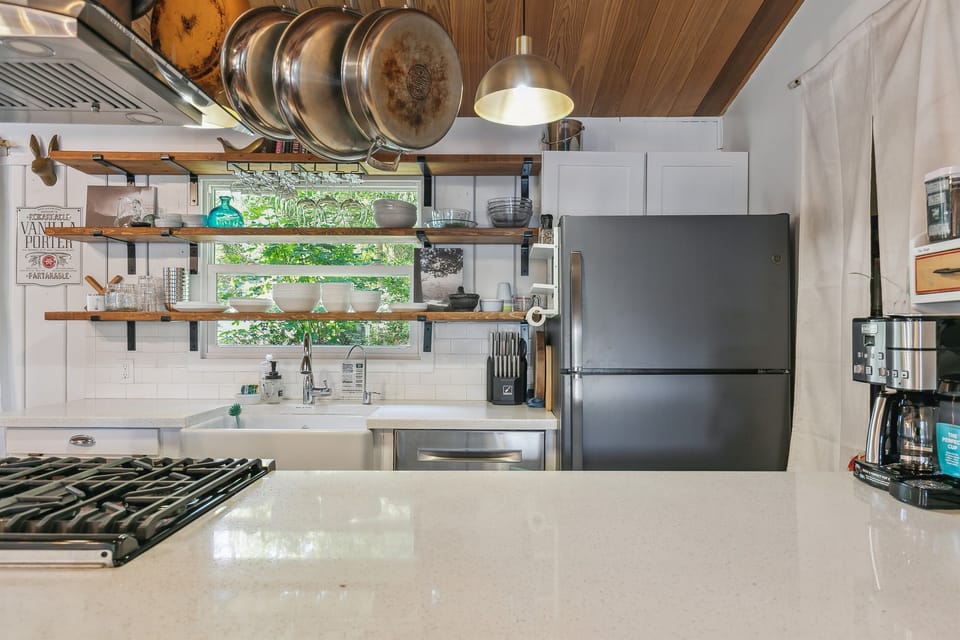 Quartz countertops, a dishwasher, and coffee station complete the spacious kitchen.