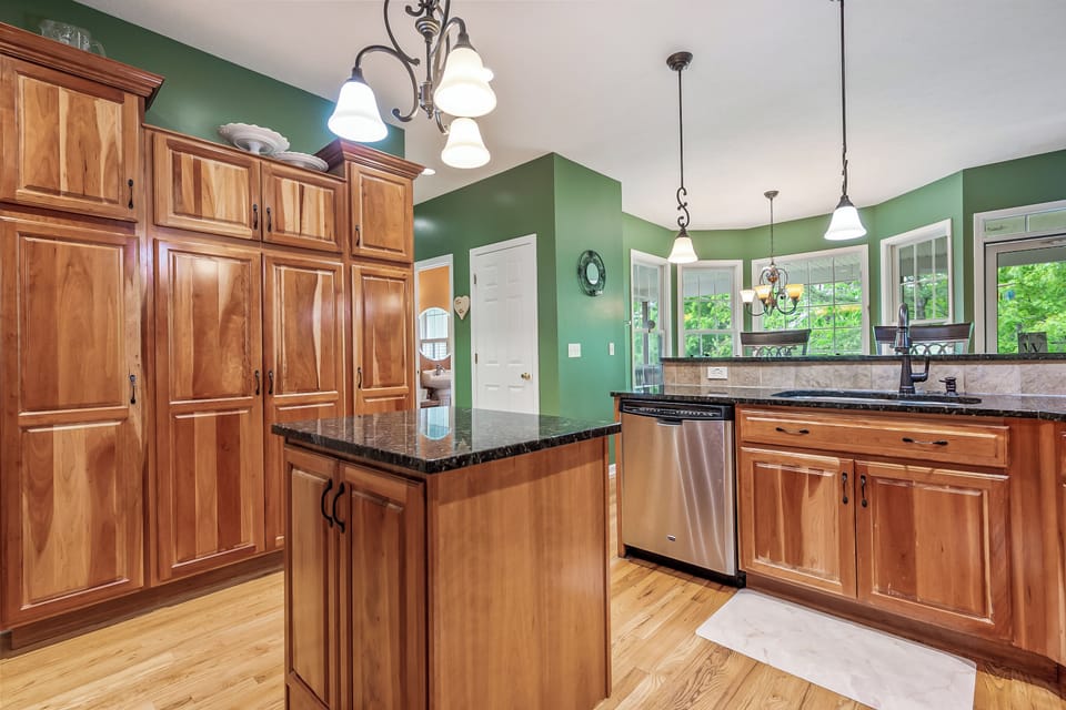 Central kitchen island with ample storage and lighting, perfect for meal prep or casual dining.