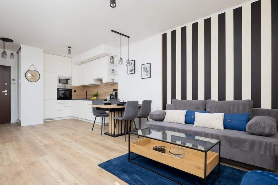 A harmonious blend of navy blue, wood, and geometric patterns creates a modern living space perfect for both relaxation and remote work.