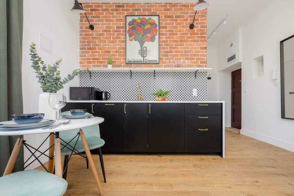 A bright kitchen with industrial touches and a brick-wall dining nook invites you to enjoy meals in a homey setting.