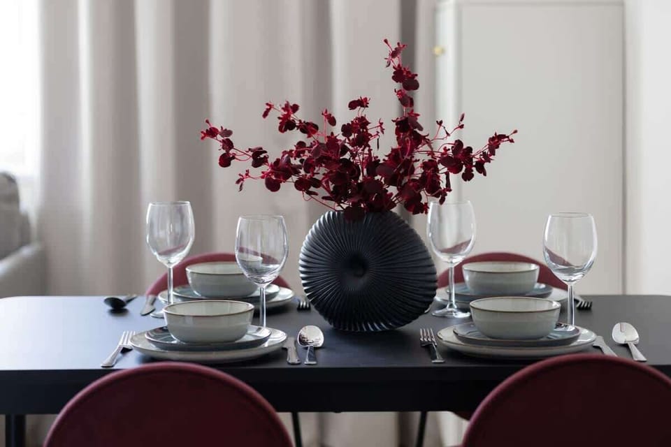 A table set for four, surrounded by bright walls and elegant tableware, invites you to share meals in a homely atmosphere.

