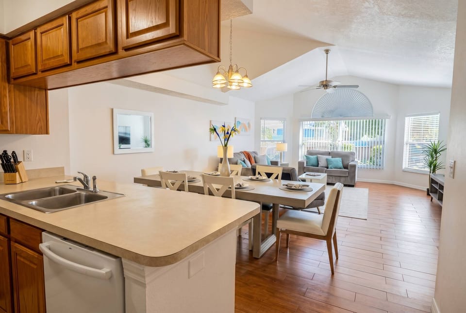Bright and airy, the open layout connects the kitchen to a stylish dining area with sleek wood accents and cozy seating. Large windows fill the space with natural light, creating an inviting atmosphere that you will love.