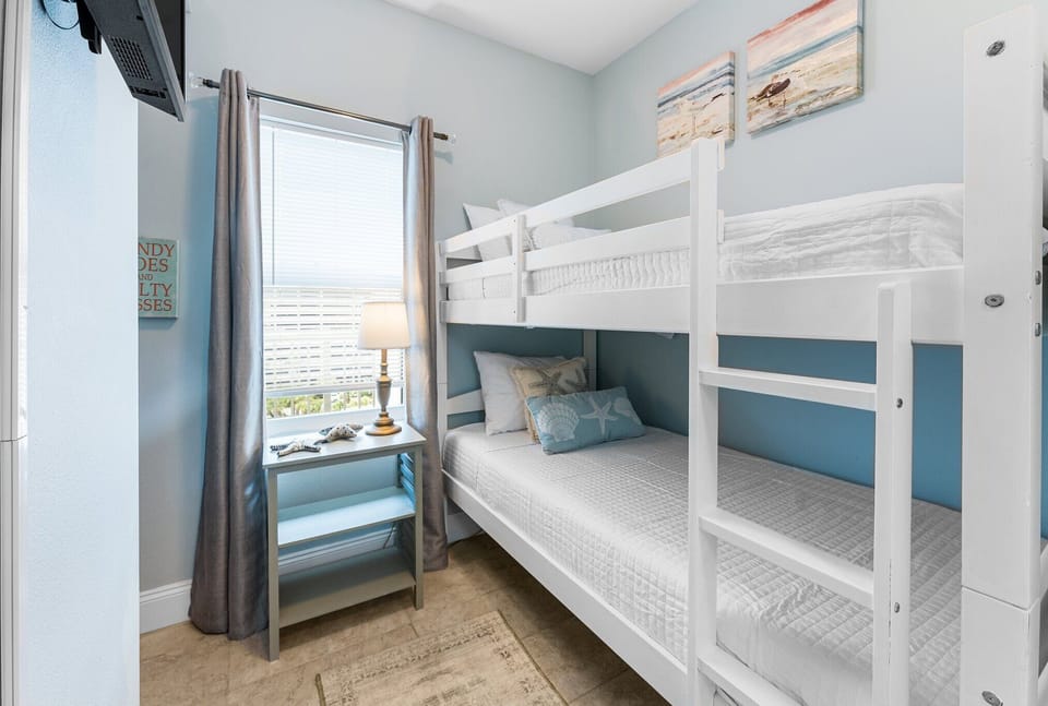 Cozy bunk bed setup in a softly lit room with ocean-themed decor.