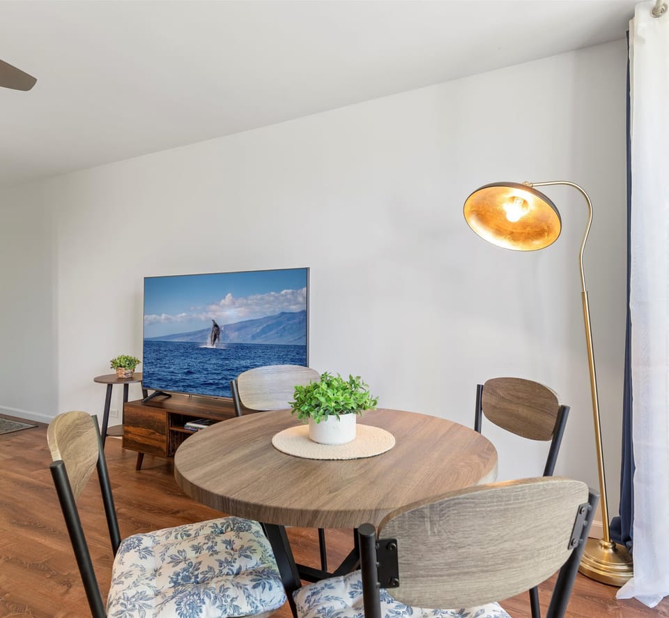 Gather around this inviting dining table where your mornings and meals unfold in bright, coastal-inspired comfort. The warm wood tones and ocean artwork create a serene backdrop for your island escape.