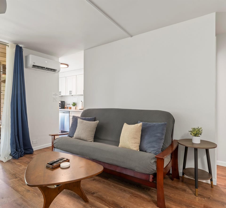 Settle into your bright living space, where a cozy futon and mid-century modern tables invite relaxation after exploring the area. Climate-controlled comfort and a stylish kitchenette make unwinding effortless.