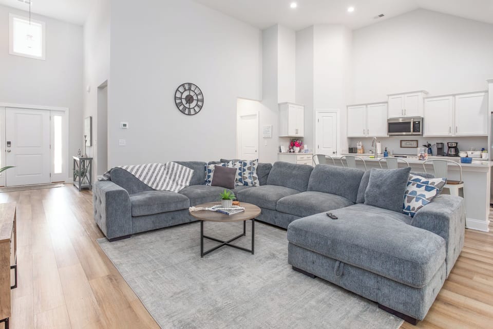 Spacious open living area with cozy sectional, vaulted ceilings, and a fully stocked kitchen—perfect for relaxing.