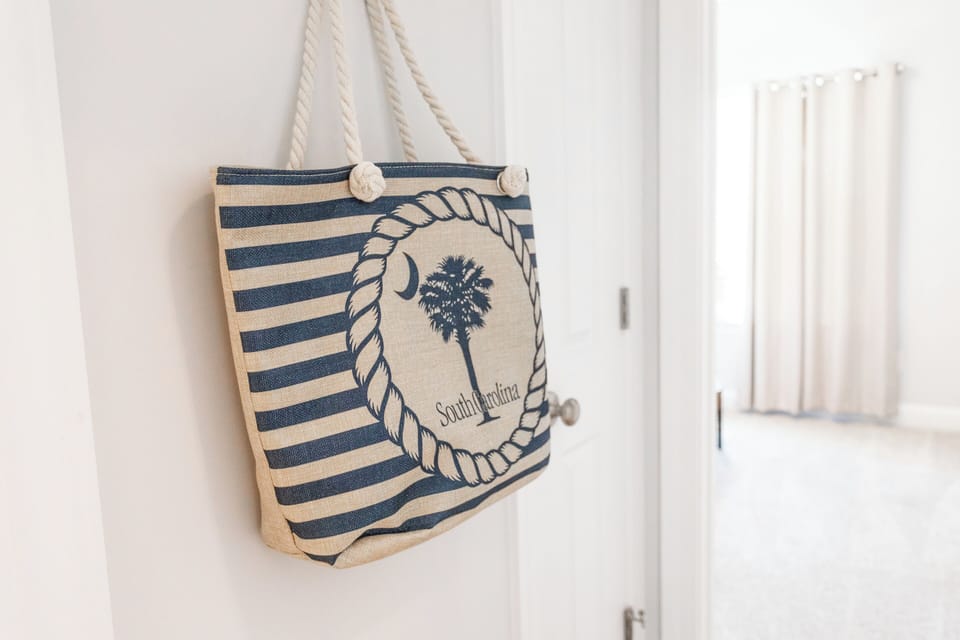Coastal-inspired interior detail featuring South Carolina tote bag, bright natural light, minimalist decor, beach vacation vibe, perfect for relaxing getaway stays.