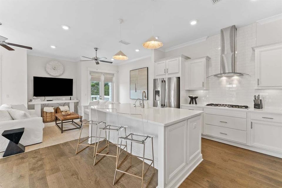 A bright and airy kitchen featuring sophisticated lighting, marble countertops, and luxury appliances.