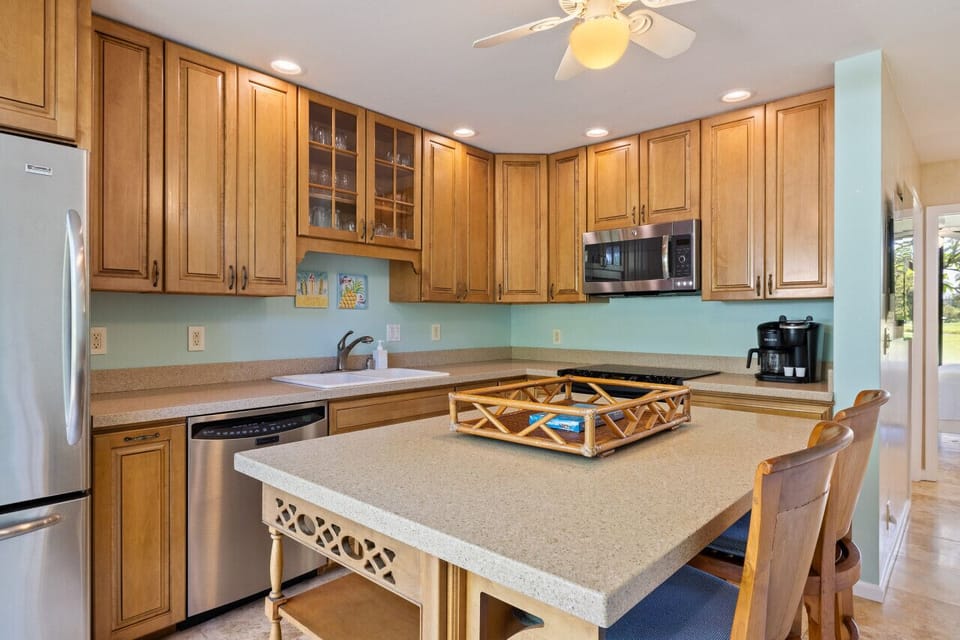 Warm kitchen w/ wood cabinetry & a roomy island ready for shared meals.