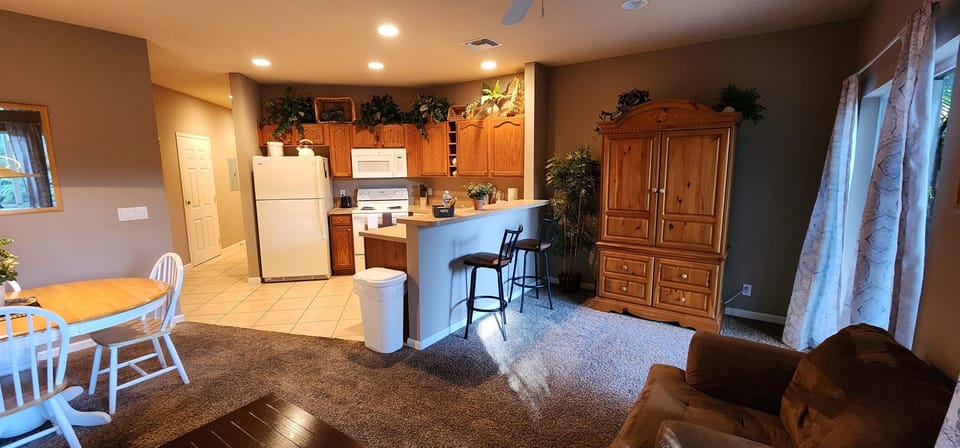 Open kitchen and living area with full-size appliances, breakfast bar seating, and a bright, functional layout.