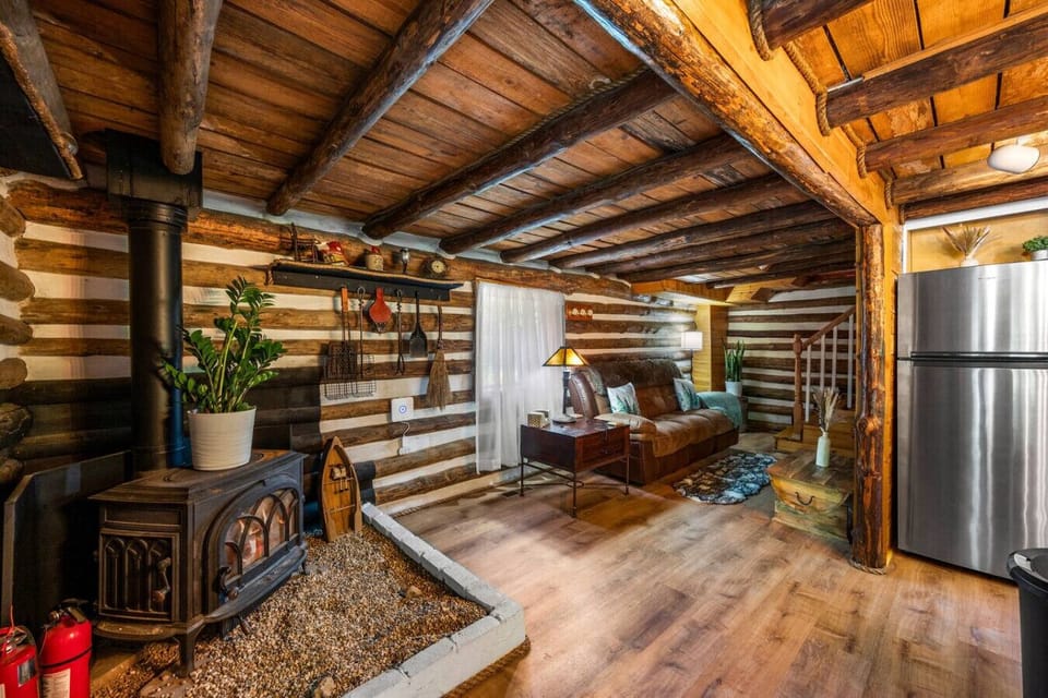 The cozy main level includes a comfortable sofa, fireplace, and kitchen.