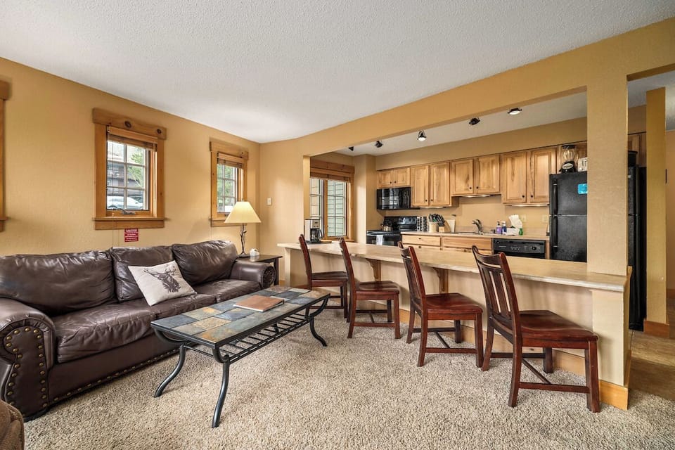 Large couch, coffee table, kitchen countertop, 4 chairs.