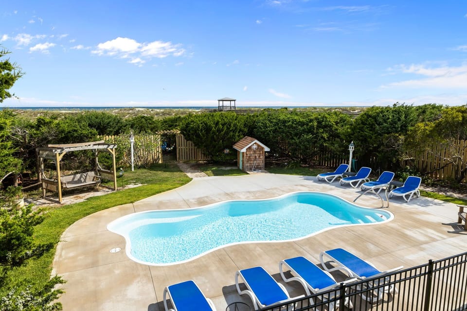 Backyard w/pool, lounge chairs, foot washing station and private gate to beach.