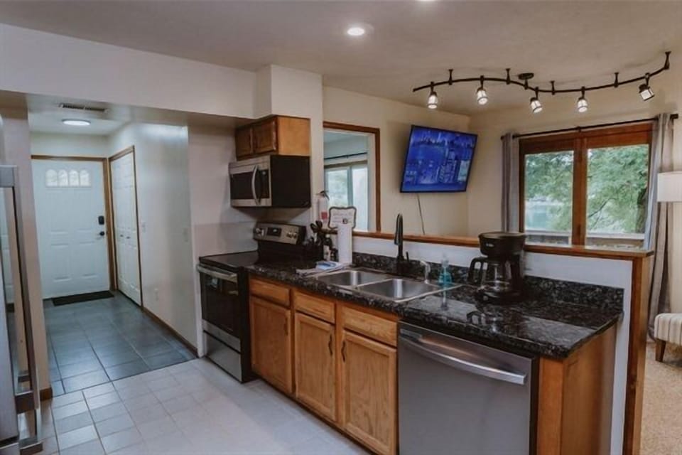 Kitchen with stainless steel stove, refrigerator, dishwasher and microwave.