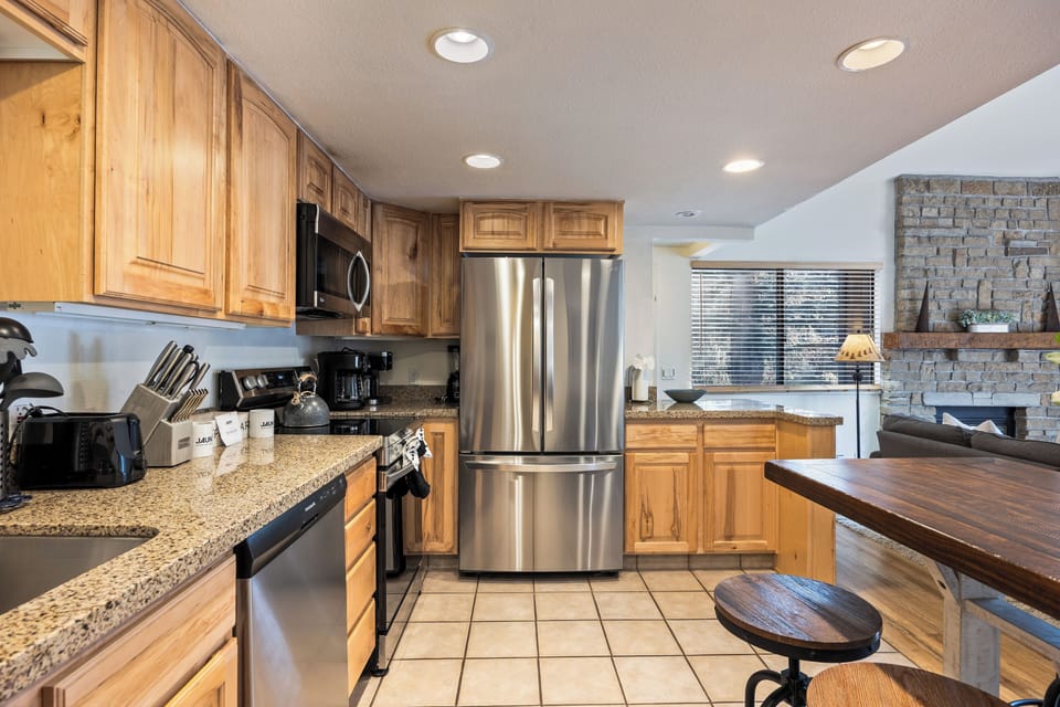 Well-equipped kitchen featuring stainless steel appliances, granite countertops, and breakfast bar seating for casual meals and conversation.