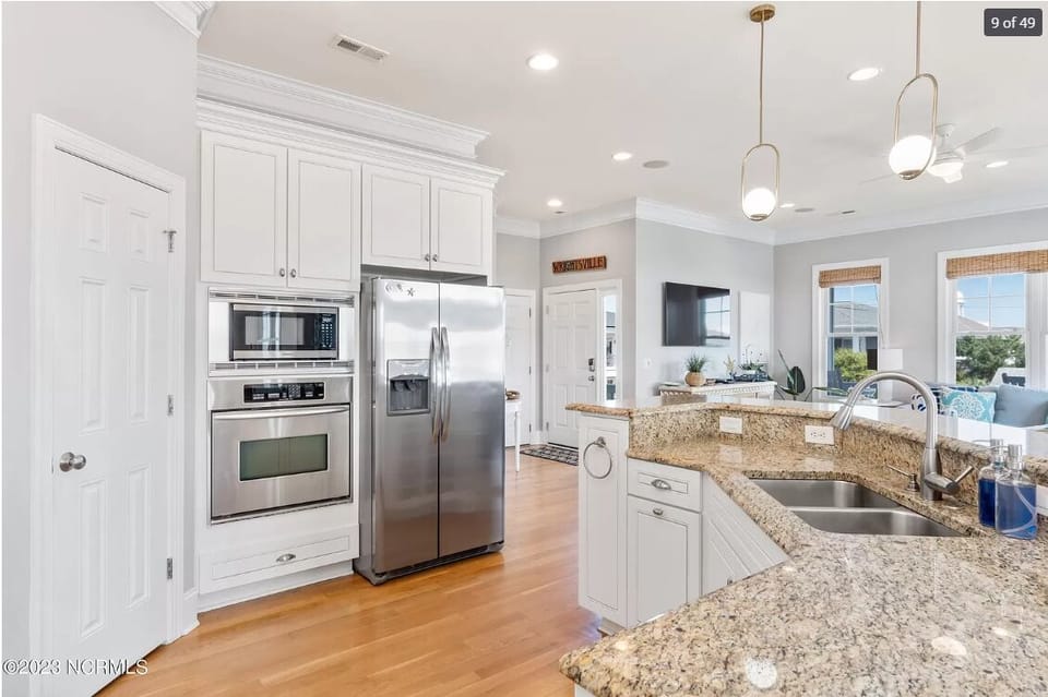 Kitchen with microwave and oven.  Separate glass top cook stove.  All pots/pans