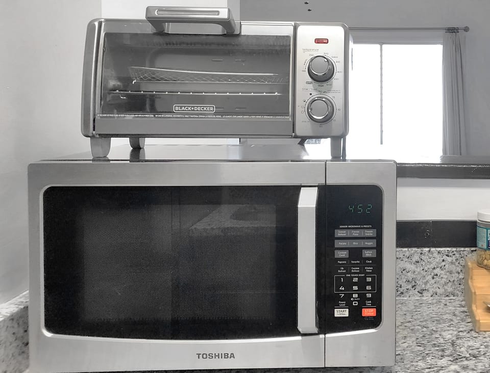 The upgraded kitchen features a stove, oven, microwave, and toaster.  