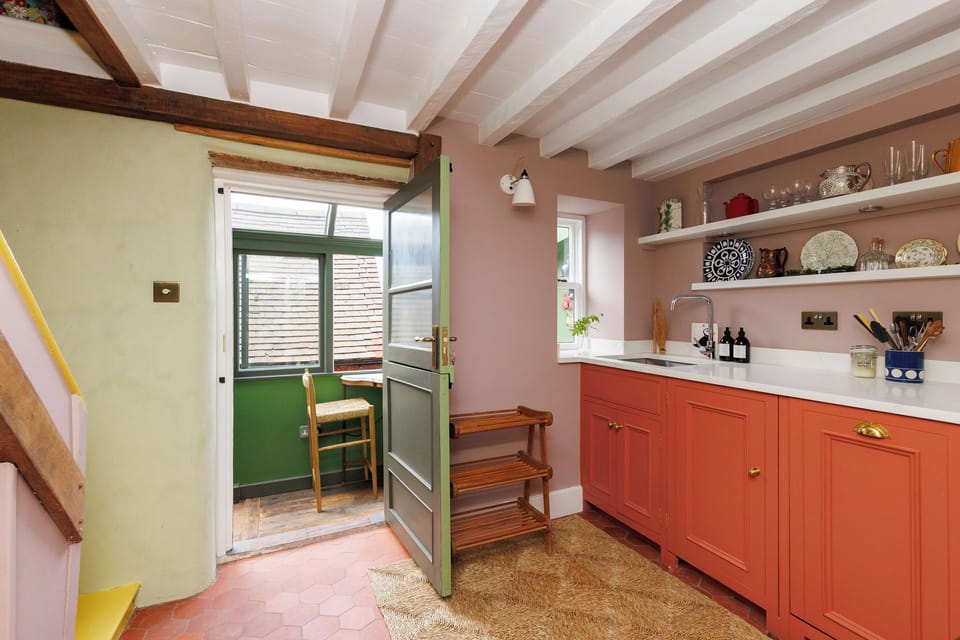 Kitchen area into the conservatory area with a breakfast table and two chairs overlooking the garden and the Arundel views. 