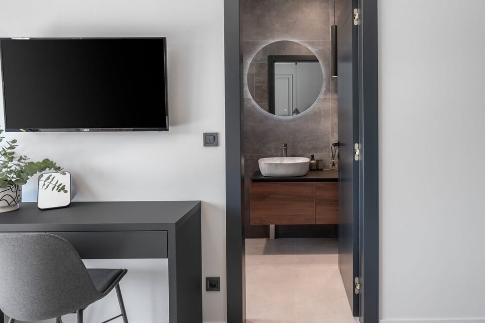 Bedroom NO2 with a king-size bed, A/C, TV, balcony overlooking the pool and surrounding landscape, and ensuite bathroom with a shower.
