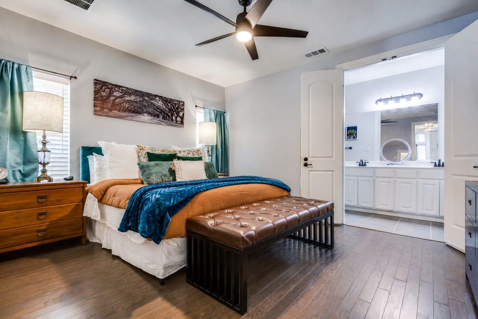 King bedroom with ceiling fan, Roku TV, dressers, and private bathroom access.