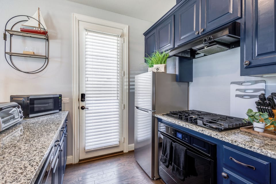 Full kitchen with refrigerator, gas stove cooktop, oven, and cooking essentials.