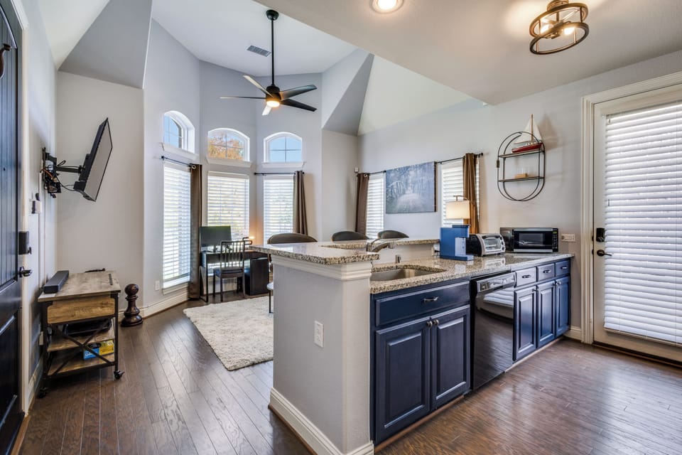 Open kitchen with farmhouse sink, dishwasher, microwave, and Keurig.