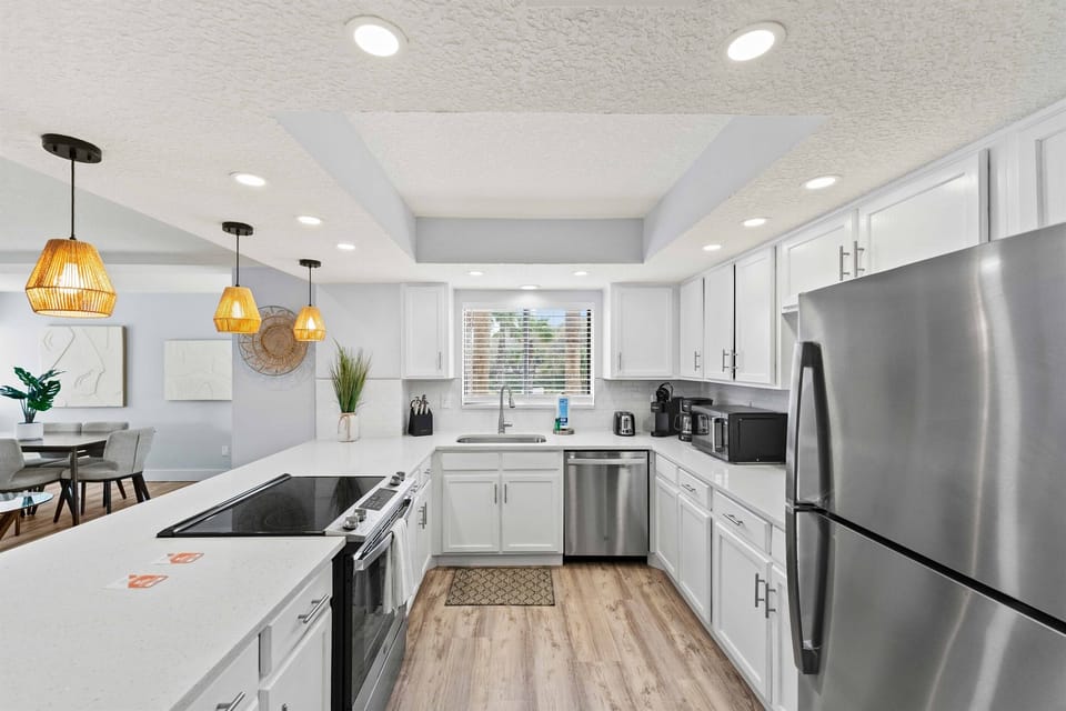 Beautifully renovated kitchen with stainless steel appliances, bright cabinetry, and a convenient breakfast bar ideal for morning coffee or casual conversations.