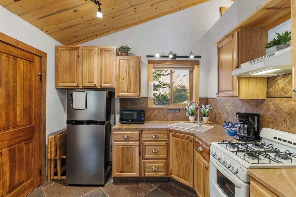 The kitchen has a gas stove, oven, microwave, coffee maker and refrigerator.