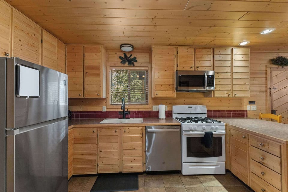 The kitchen has a dishwasher, microwave, refrigerator, gas stove, toaster and coffee maker.