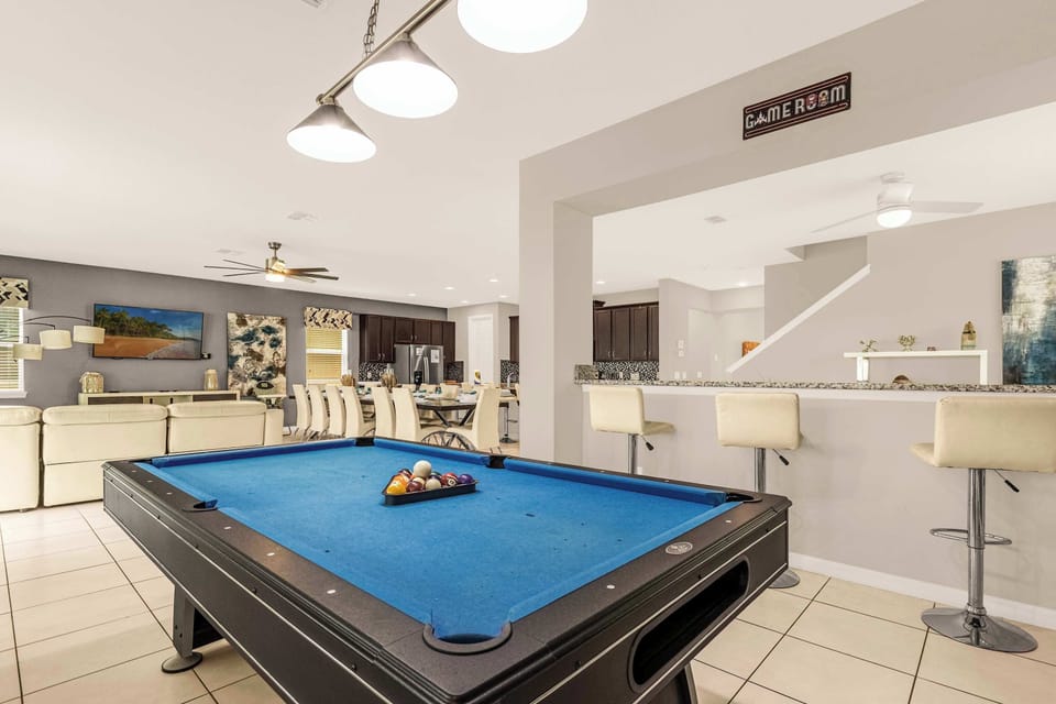 Enjoy endless fun in this stylish game room with a pool table, cozy seating, and a large dining area perfect for gatherings.