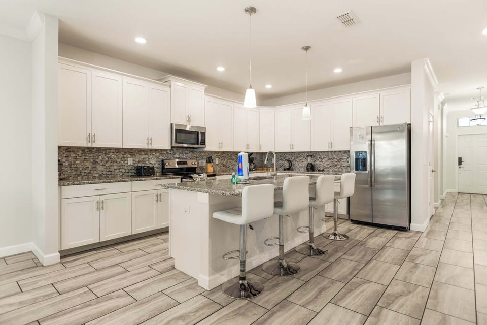 Modern kitchen with sleek finishes and ample seating, perfect for entertaining and family meals.