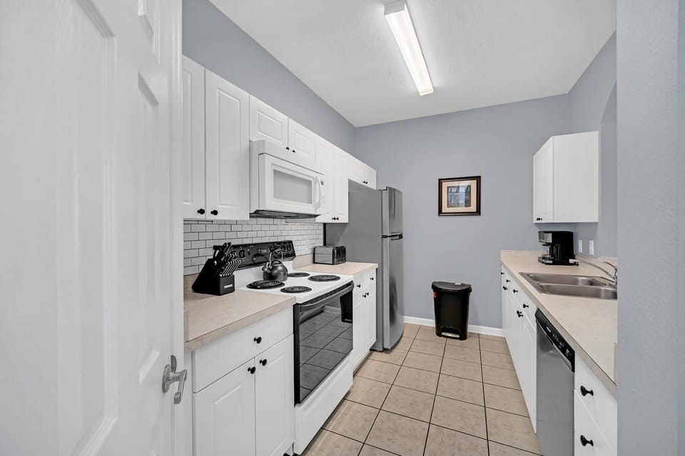 Modern kitchen with white cabinetry and stainless steel appliances