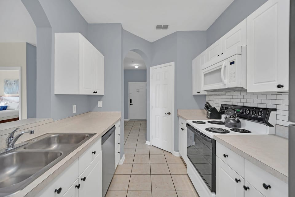Modern kitchen with white cabinetry and stainless steel appliances