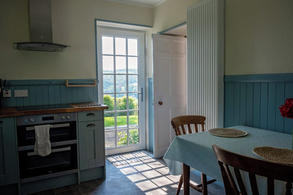 Kitchen showing doorway to downstairs living room and garden