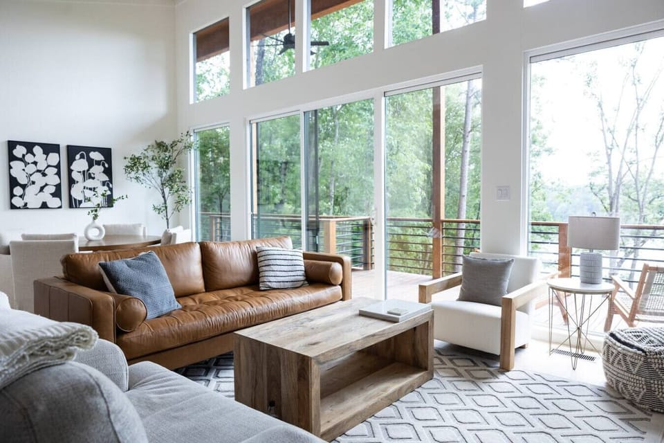 Bright, modern lakefront living on Lewis Smith Lake.  This open-concept space features soaring ceilings, expansive windows, and stunning water views that fill the room with natural light.  Step onto the private deck overlooking the lake, or relax in the c