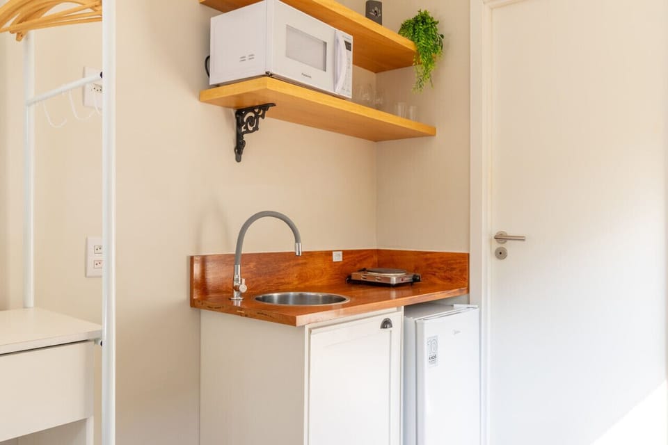 Cozinha compacta, porém completa: panelas e frigideira, pratos, talheres, copos, taças e canecas, abridor de lata e saca rolha, fogão elétrico, sanduicheira, cafeteira, microondas, chaleira elétrica e frigobar