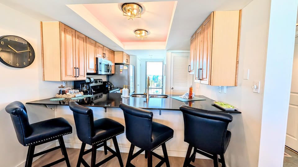 Black granite countertop wraps around the kitchen with large countertop space