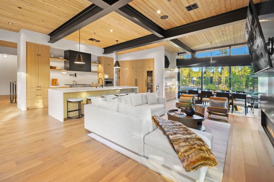 Living Room 1: L-shaped couch, gas fireplace, 75” TV, open to kitchen and dining room, upper floor